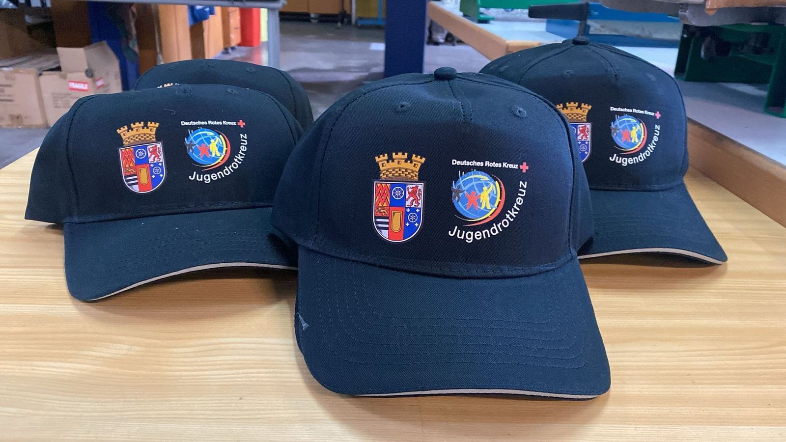 Bedruckte Caps mit Wappen und Logo des Jugendrotkreuzes